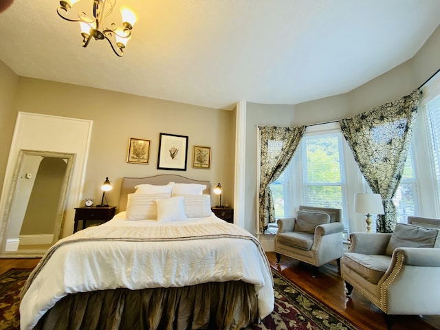 bedroom featuring a chandelier and wood finished floors