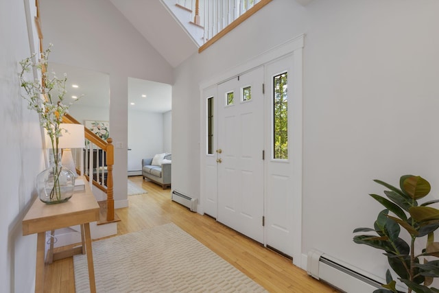 11 Oxford Rd, Windham, ME 04062 - entrance foyer featuring light wood finished floors, high vaulted ceiling, baseboard heating, stairway, and a baseboard heating unit