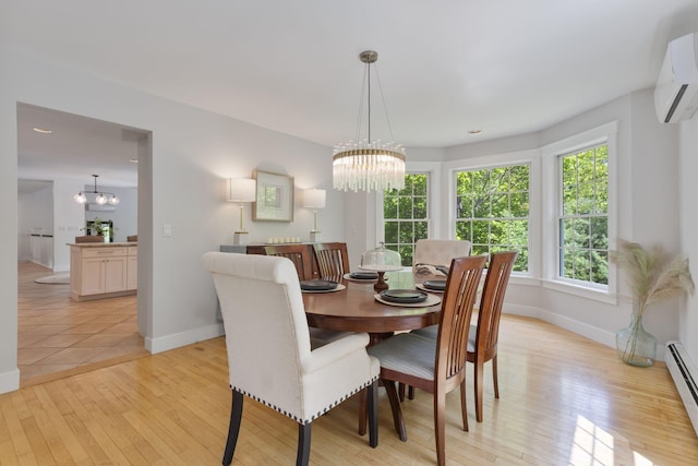 11 Oxford Rd, Windham, ME 04062 - dining area featuring a chandelier, a wall mounted AC, baseboards, and light wood finished floors
