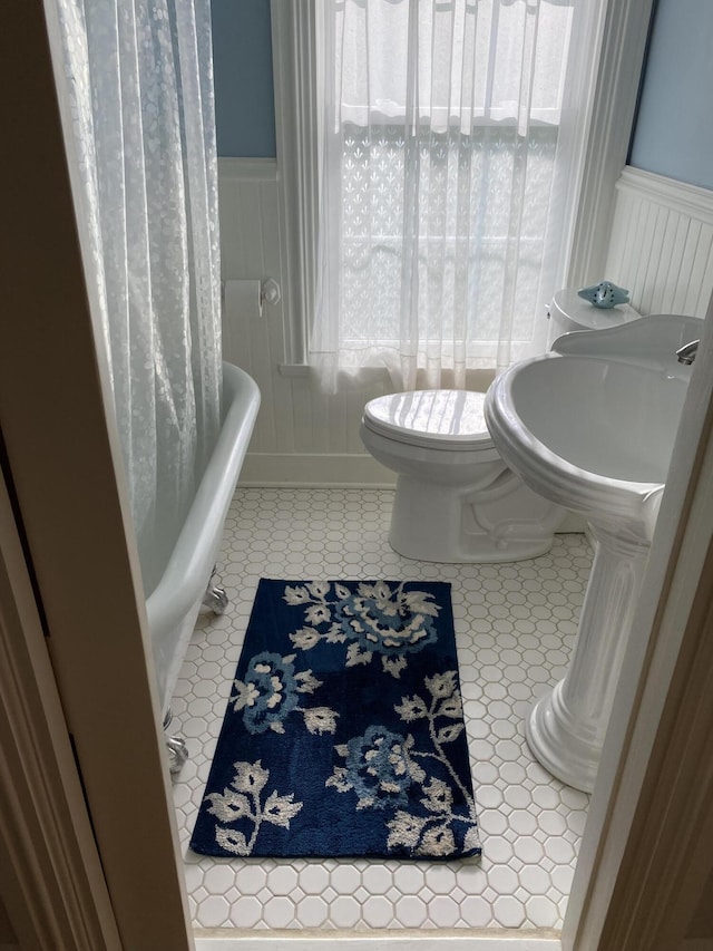 12 Old Rte 1, Searsport, ME 04974 - bathroom featuring toilet, wainscoting, a bath, a shower with shower curtain, and a sink