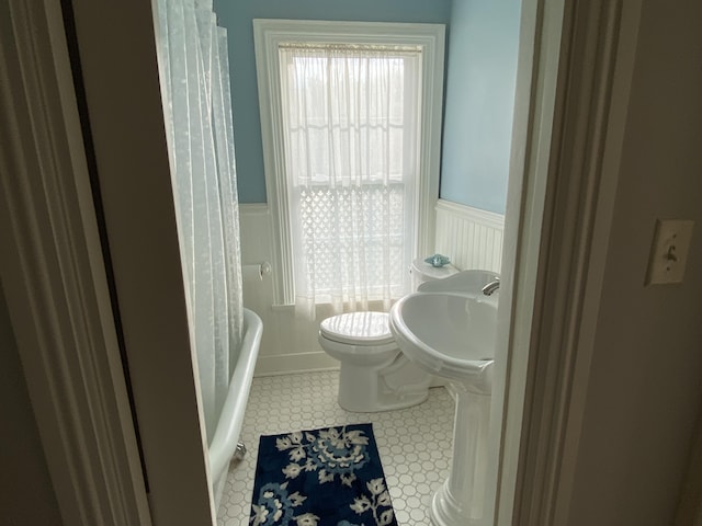 12 Old Rte 1, Searsport, ME 04974 - bathroom featuring wainscoting, toilet, a decorative wall, a tub, and a sink