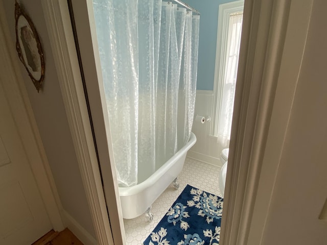 12 Old Rte 1, Searsport, ME 04974 - bathroom with a bath, a decorative wall, toilet, wainscoting, and a shower with shower curtain