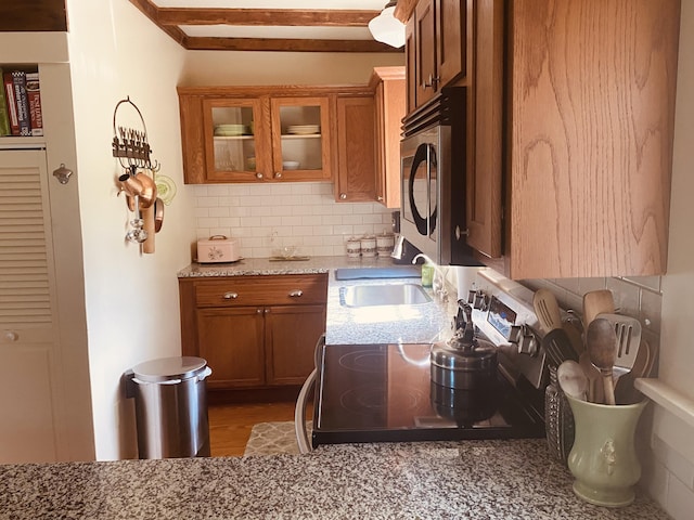 12 Old Rte 1, Searsport, ME 04974 - kitchen with stainless steel microwave, a sink, brown cabinetry, and decorative backsplash