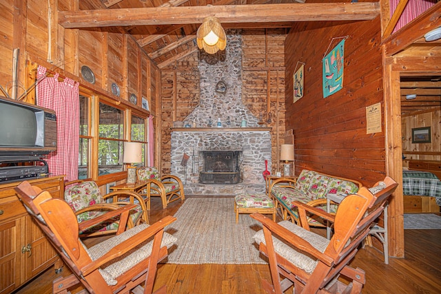 106 Shady Ln, Parsonsfield, ME 04047 - living room with high vaulted ceiling, wooden ceiling with exposed beams, wood walls, wood-type flooring, and a stone fireplace