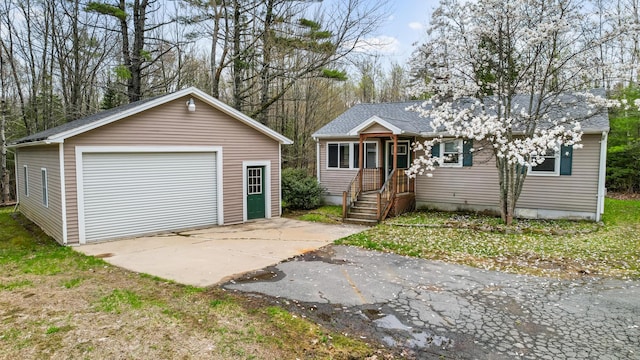 227 Forest Ave, Orono, ME 04473 - view of front facade with a detached garage, asphalt driveway, an outbuilding, and a shingled roof