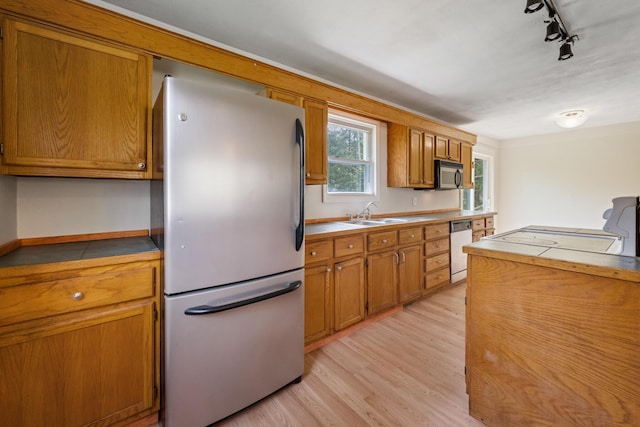 227 Forest Ave, Orono, ME 04473 - kitchen featuring appliances with stainless steel finishes, brown cabinets, light wood finished floors, track lighting, and a sink