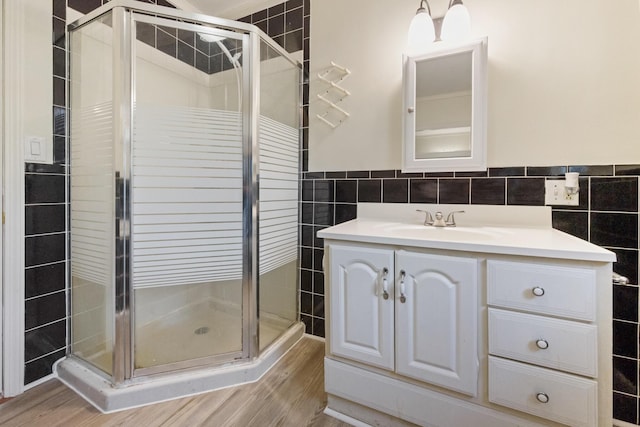 227 Forest Ave, Orono, ME 04473 - full bath with tile walls, a shower stall, wood finished floors, vanity, and a wainscoted wall