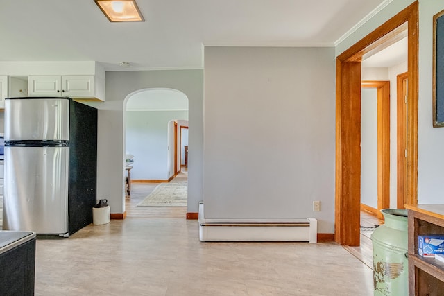 hall with arched walkways, a baseboard heating unit, ornamental molding, and baseboards