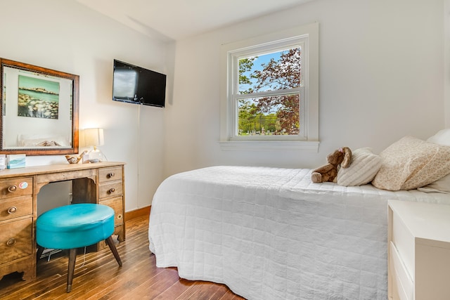 bedroom featuring wood finished floors and baseboards