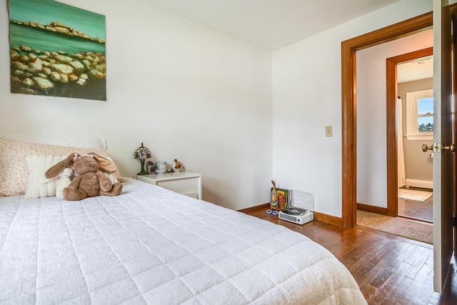 bedroom featuring hardwood / wood-style flooring and baseboards