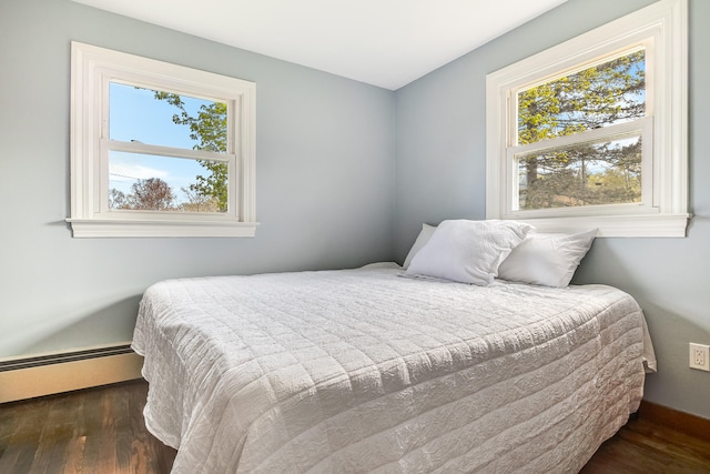 bedroom featuring wood finished floors and baseboard heating