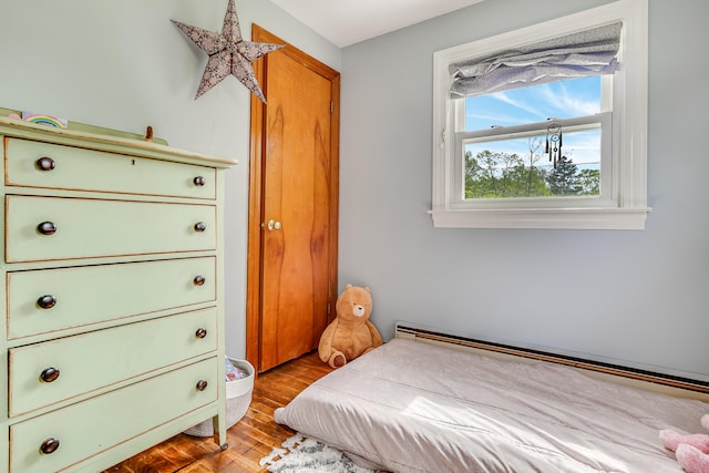 bedroom featuring wood finished floors and baseboard heating