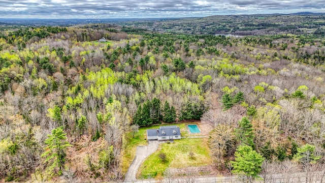 aerial view of property and surrounding area with a heavily wooded area