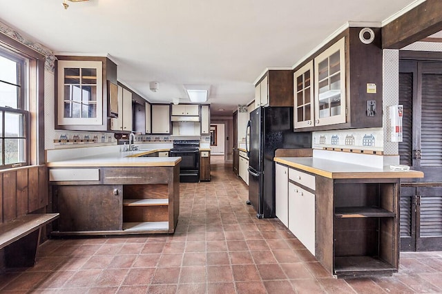 kitchen featuring open shelves, black appliances, dark brown cabinetry, light countertops, and a sink
