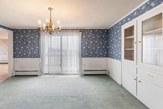 unfurnished dining area with wallpapered walls, wainscoting, a textured ceiling, a chandelier, and a baseboard heating unit