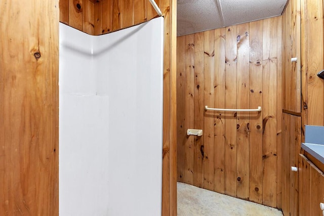 full bathroom featuring wooden walls and a shower