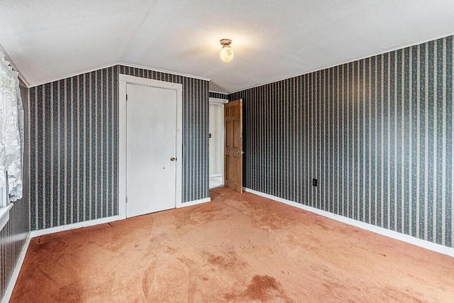 bonus room with lofted ceiling, wallpapered walls, carpet floors, and baseboards