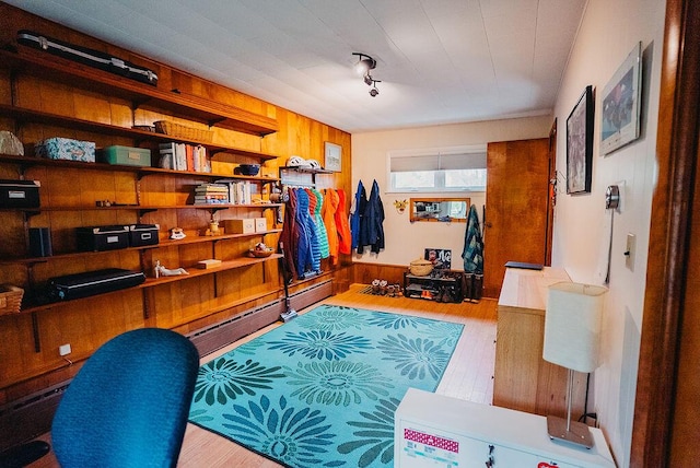 home office with wood finished floors, wood walls, and baseboard heating