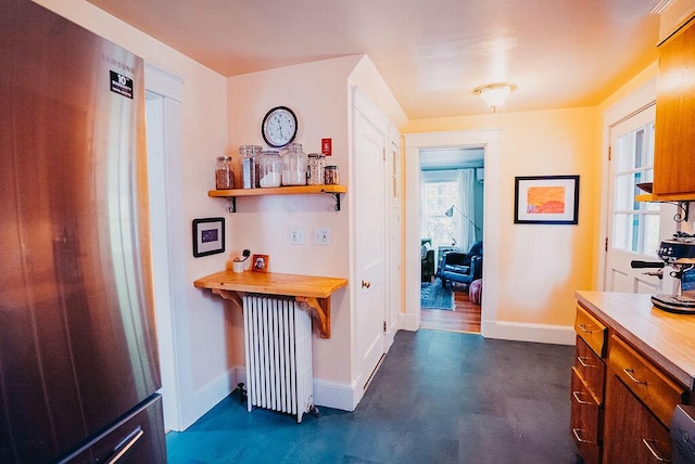 hall featuring radiator heating unit and baseboards