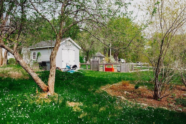 view of grassy yard featuring a storage shed and an outbuilding
