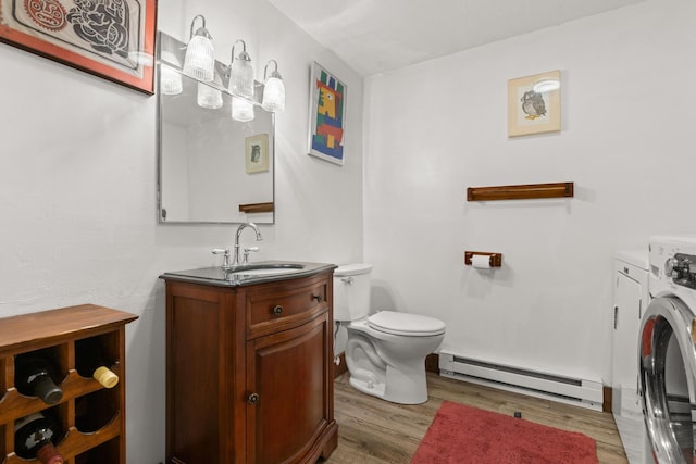 28 Ridgewood Dr, Eliot, ME 03903 - half bathroom featuring a baseboard radiator, washer / clothes dryer, wood finished floors, vanity, and toilet