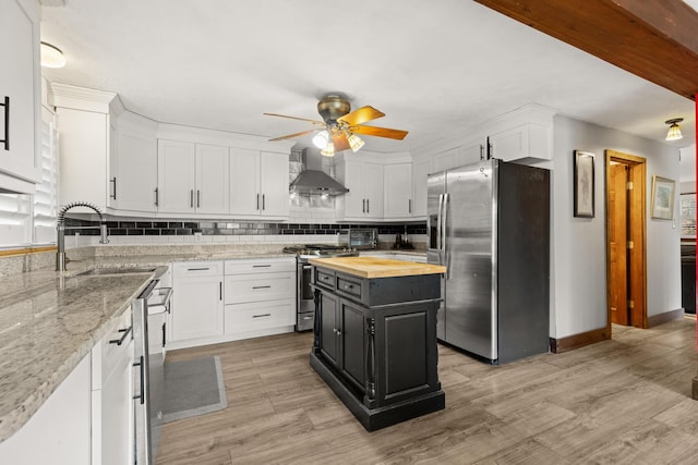 28 Ridgewood Dr, Eliot, ME 03903 - kitchen with appliances with stainless steel finishes, butcher block countertops, wall chimney exhaust hood, white cabinets, and a ceiling fan