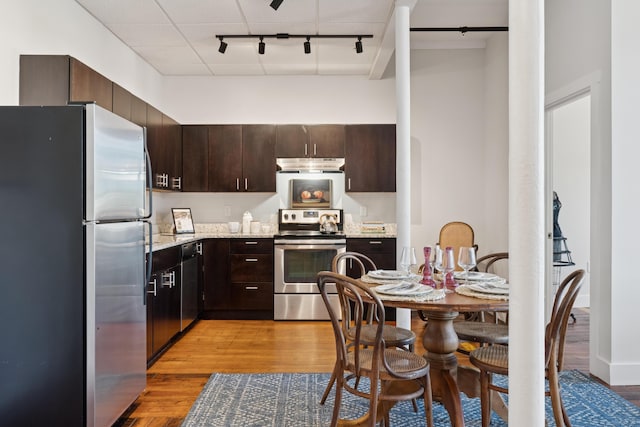 2 Main St Unit 17-410, Biddeford, ME 04005 - kitchen with appliances with stainless steel finishes, under cabinet range hood, light wood finished floors, and rail lighting