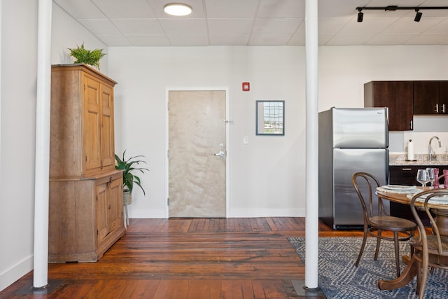 2 Main St Unit 17-410, Biddeford, ME 04005 - kitchen featuring freestanding refrigerator, dark wood-type flooring, baseboards, light stone countertops, and a sink