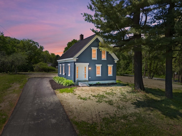 558 High St, West Gardiner, ME 04345 - view of front of house with driveway, a chimney, and metal roof