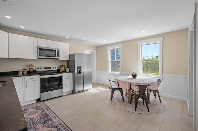 558 High St, West Gardiner, ME 04345 - kitchen with stainless steel appliances, a wainscoted wall, dark countertops, white cabinets, and recessed lighting