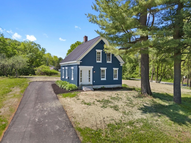 558 High St, West Gardiner, ME 04345 - view of front facade with driveway, a chimney, and metal roof