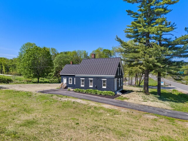 558 High St, West Gardiner, ME 04345 - view of front facade with a chimney, metal roof, and a front yard