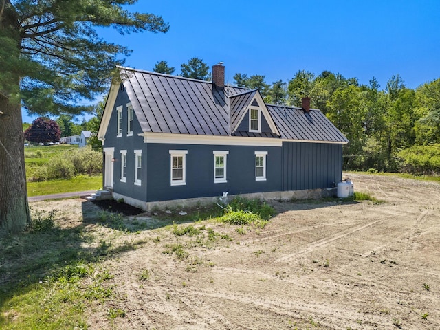 558 High St, West Gardiner, ME 04345 - view of side of home with a standing seam roof, a chimney, and metal roof