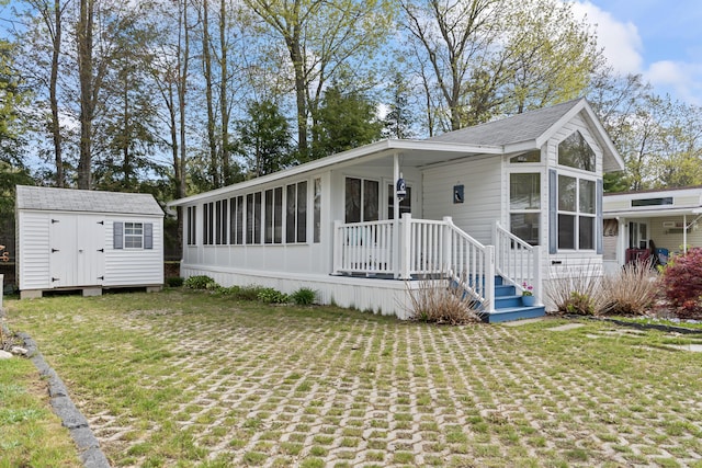 430 Post Rd Unit 139, Wells, ME 04090 - manufactured / mobile home featuring a sunroom, an outdoor structure, a front lawn, and a storage shed