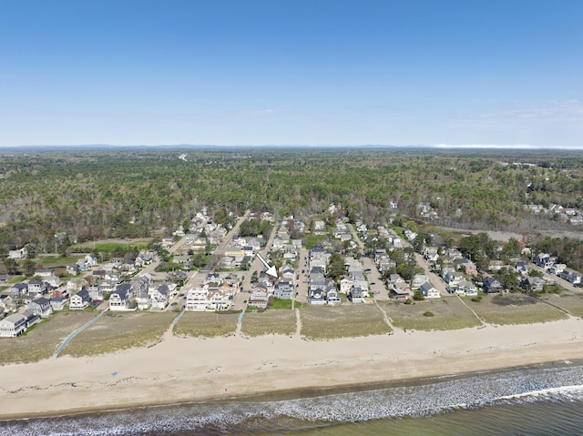 view of property location with a large body of water, a heavily wooded area, and nearby suburban area