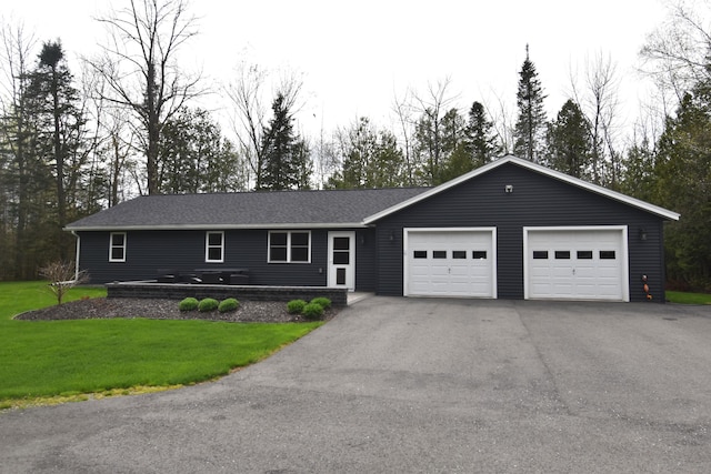 ranch-style house with driveway, an attached garage, and a front lawn