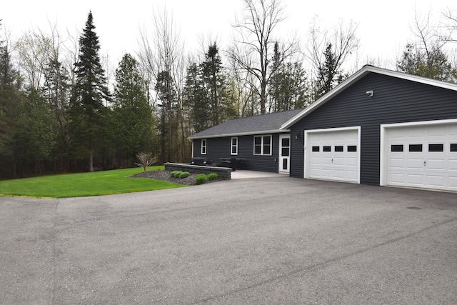 ranch-style house featuring an attached garage, driveway, and a front yard