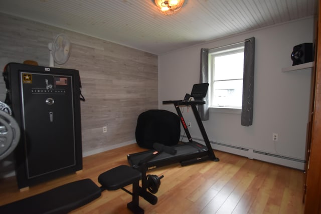 workout room featuring wooden walls, a baseboard heating unit, wood finished floors, an accent wall, and wooden ceiling