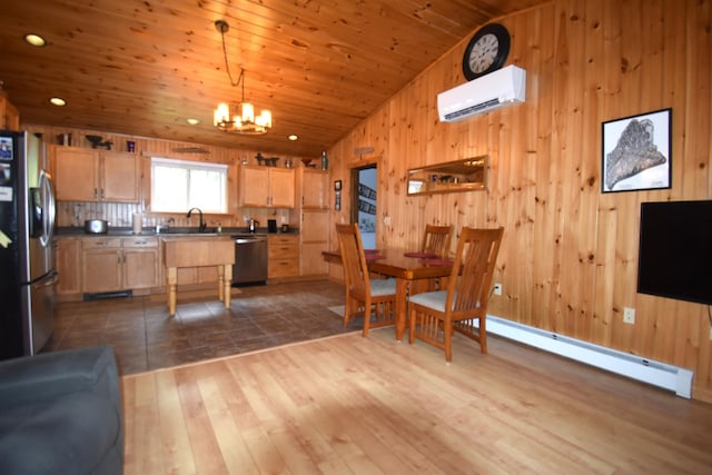 kitchen featuring stainless steel appliances, a wall unit AC, a sink, vaulted ceiling, and a chandelier