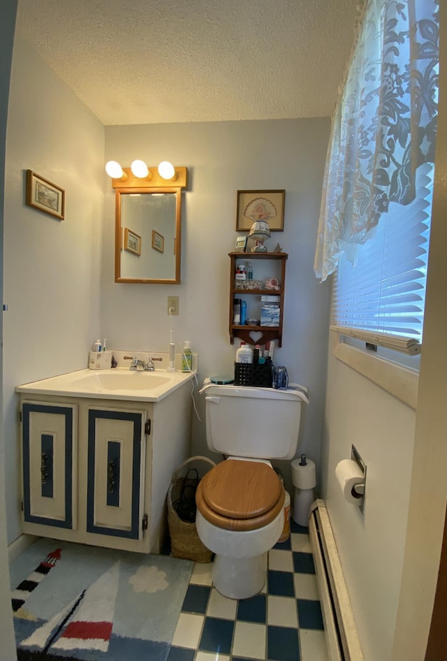 17 Canterbury Rd, Brewer, ME 04412 - bathroom with tile patterned floors, a baseboard heating unit, a textured ceiling, toilet, and vanity