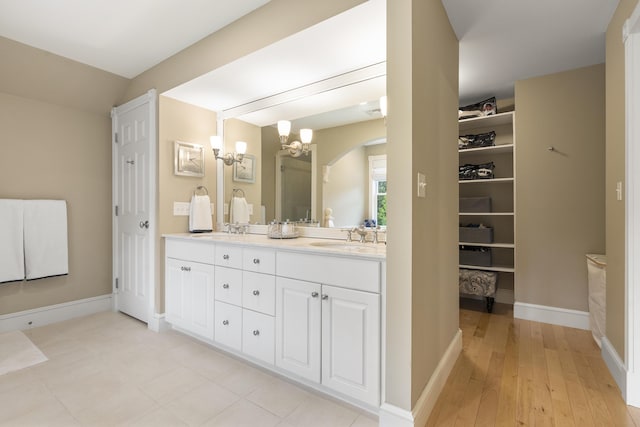 9 Edes Rd, Cumberland, ME 04021 - bathroom with a chandelier, double vanity, hardwood / wood-style flooring, and baseboards
