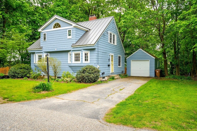 99 Spring St, Saco, ME 04072 - view of front of house featuring an outbuilding, a chimney, a garage, a standing seam roof, and driveway