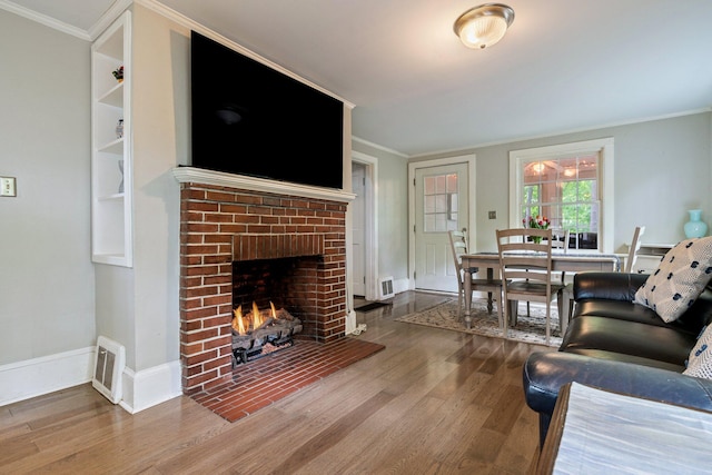 99 Spring St, Saco, ME 04072 - living area with wood finished floors, ornamental molding, and a brick fireplace
