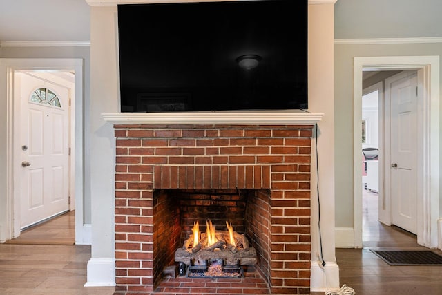 99 Spring St, Saco, ME 04072 - detailed view of a fireplace, crown molding, baseboards, and wood finished floors