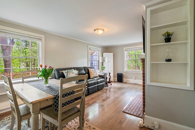 99 Spring St, Saco, ME 04072 - dining space featuring healthy amount of natural light, wood-type flooring, crown molding, baseboards, and built in features