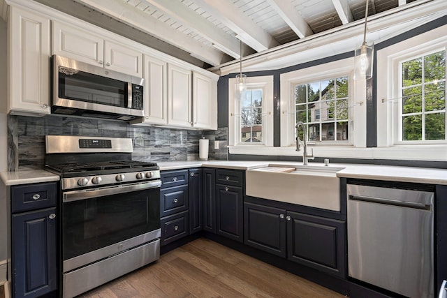 99 Spring St, Saco, ME 04072 - kitchen featuring appliances with stainless steel finishes, a sink, white cabinetry, backsplash, and wooden ceiling with exposed beams