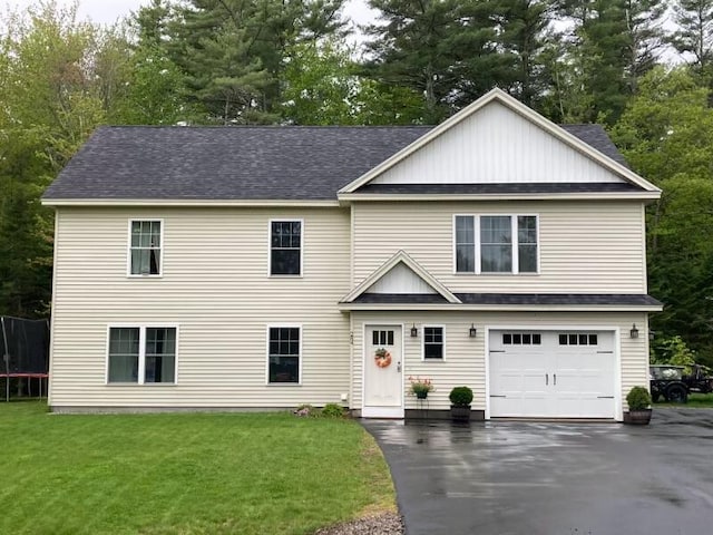 284 Roosevelt Trl, Windham, ME 04062 - view of front of property featuring a front yard, driveway, a trampoline, an attached garage, and roof with shingles