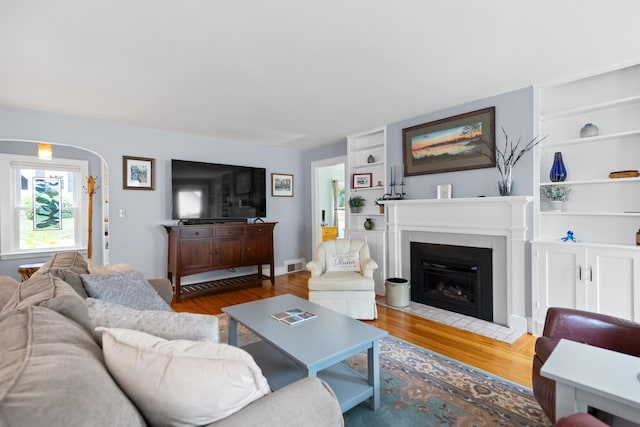 23 Amerescoggin Rd, Falmouth, ME 04105 - living area featuring wood finished floors, built in features, and a tile fireplace