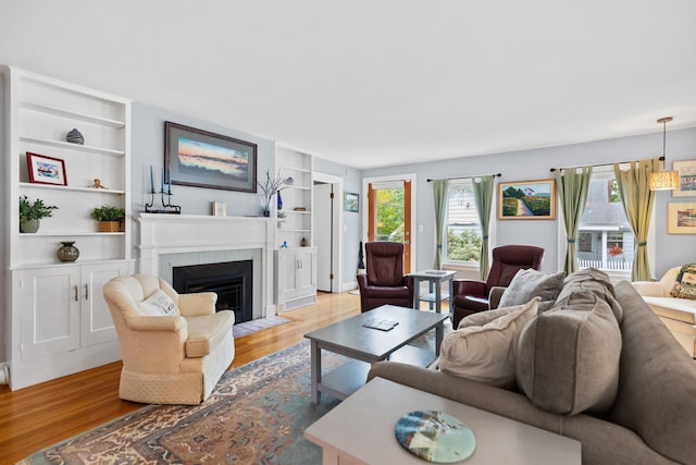 23 Amerescoggin Rd, Falmouth, ME 04105 - living room with light wood finished floors, built in features, and a fireplace with flush hearth