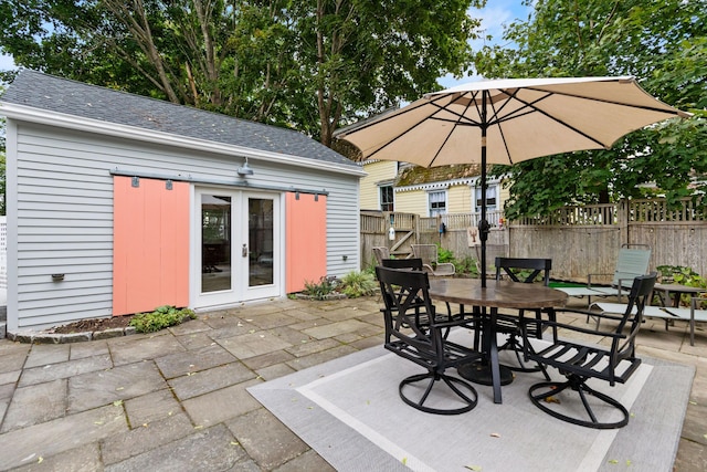 23 Amerescoggin Rd, Falmouth, ME 04105 - view of patio / terrace with french doors, fence, outdoor dining area, and an outbuilding